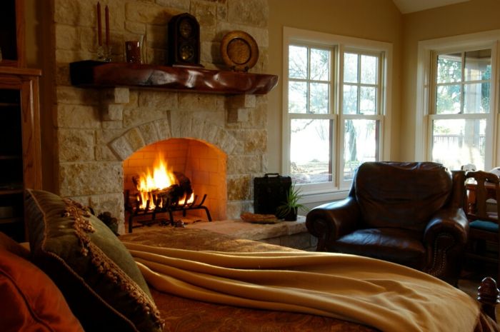 tegel öppen spis sovrum-dubbelsäng-gul-sovande filt-läderfåtöljer och mörkbrun-antik hörnfönster