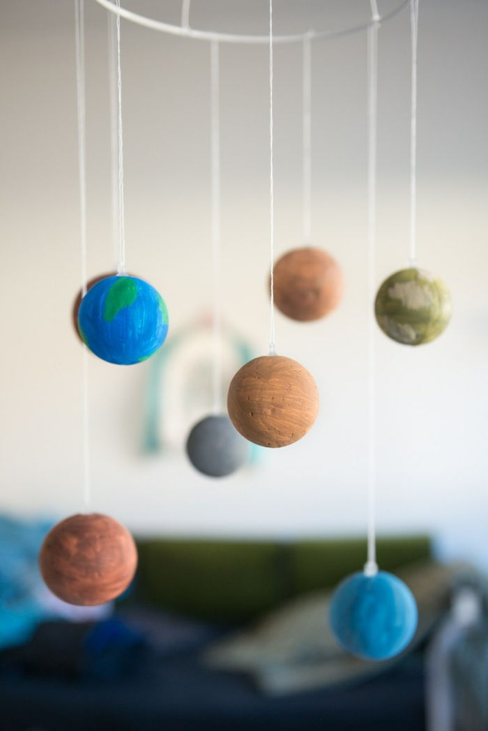 Solarni sistem iz polistirenskih kroglic, majhnih planetov pobarvan z barvami in pritrjen z nitjo