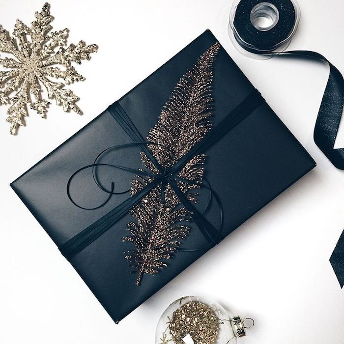 Elegantný darčekový darček v čiernej farbe, dekorácia peria, vianočná guľa