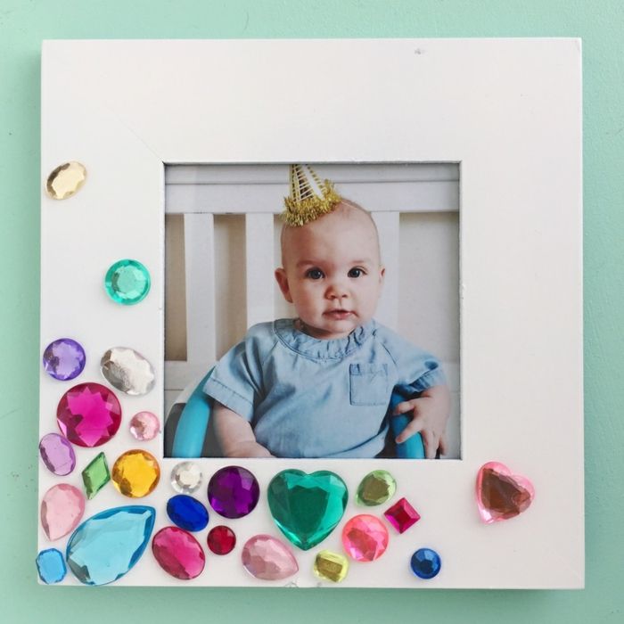 Podajte fotookvir za rojstvo, priložite barvite kristale z lepilom, srčkan otroka s stransko kapo