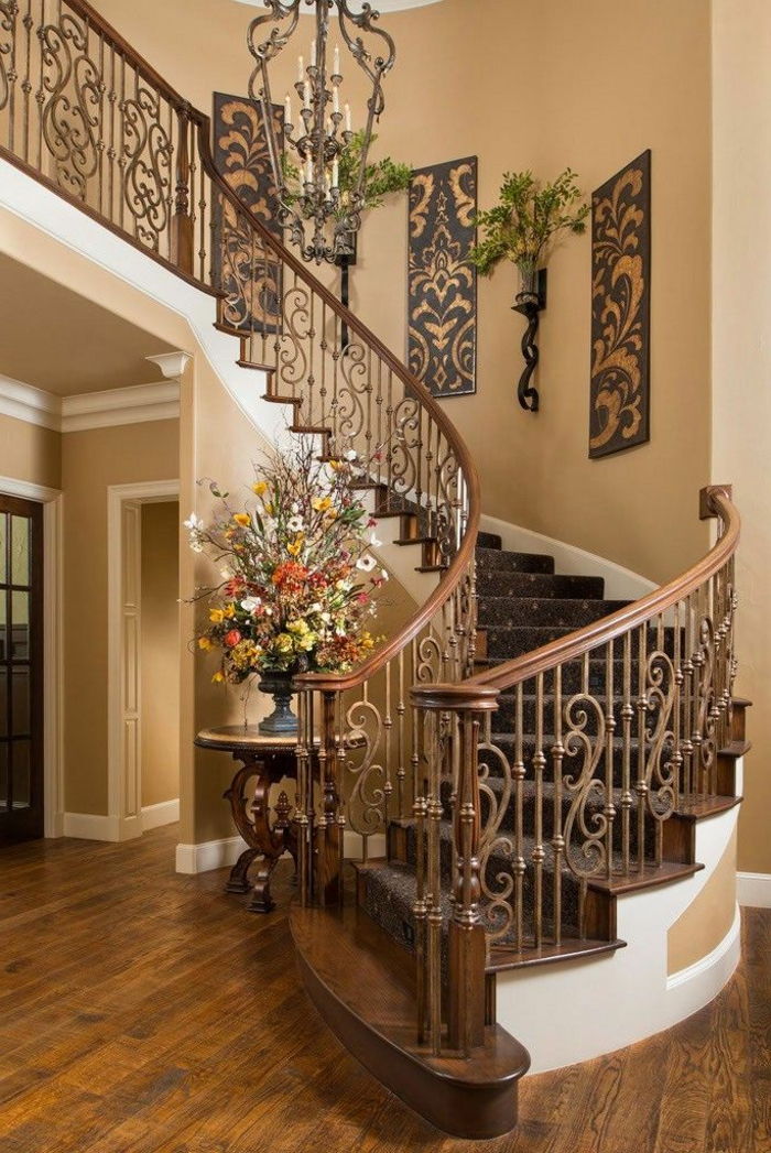 Spiralne stopnice s spretnim lesnim rezbarjem na oklepu, lepimi murali in vazami - stopniščnimi zamislimi
