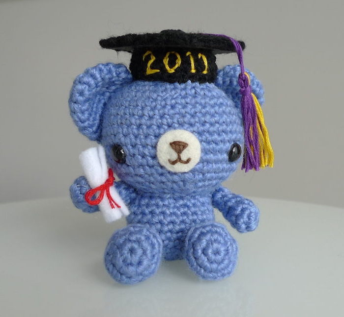 un ursuleț de pluș albastru, cu o pălărie neagră și o diplomă - cadouri pentru absolvirea liceului