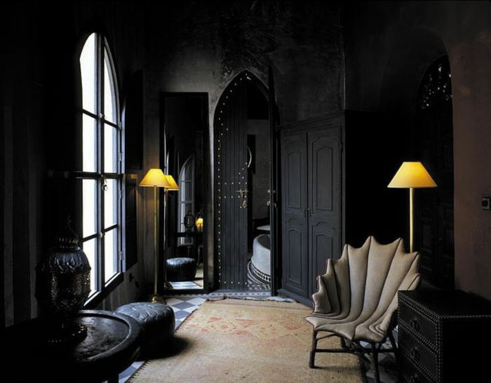 Relaxecke cu fotoliu gotic, covor în culori naturale, pereți negri, sertare negre, lămpi cu două etaje