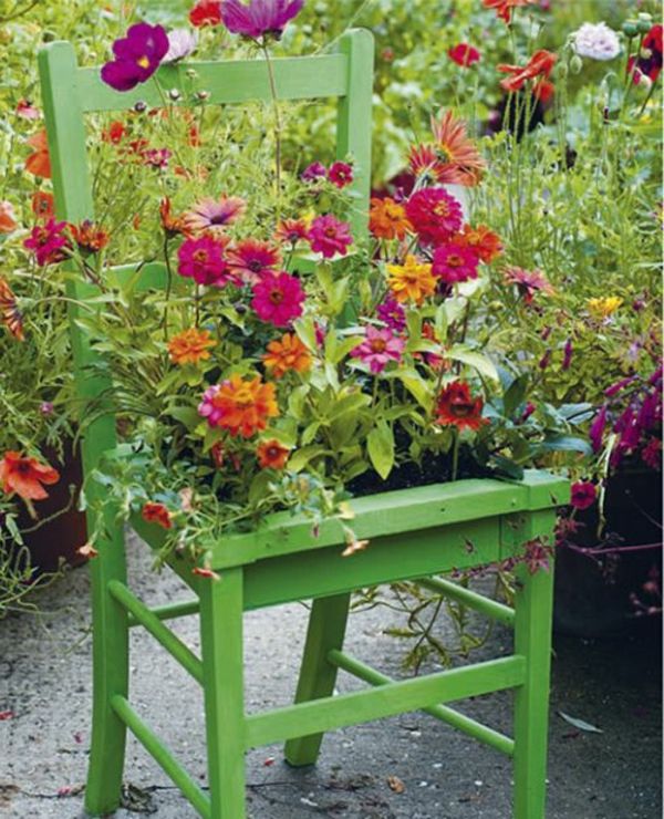 Grön stol som dekoration med blomkruka