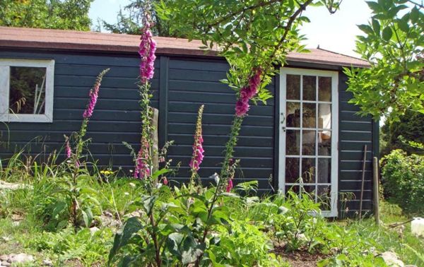 šedý záhradný dom švédsky štýl - kvety v fialovej farbe
