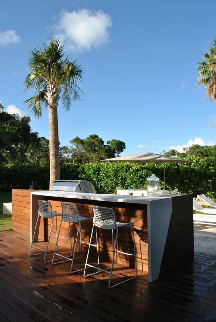 una cucina barbecue con bancone accanto alla piscina del giardino