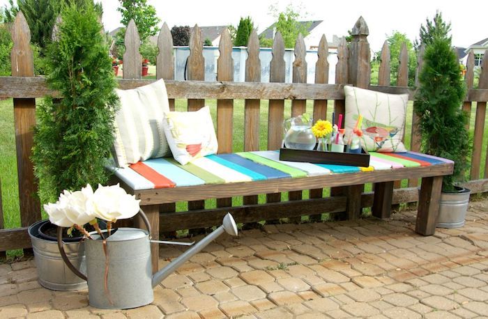 jardinagem fotos - um banco de jardim de madeira com três almofadas brancas - jardim e flores brancas e jardim portão