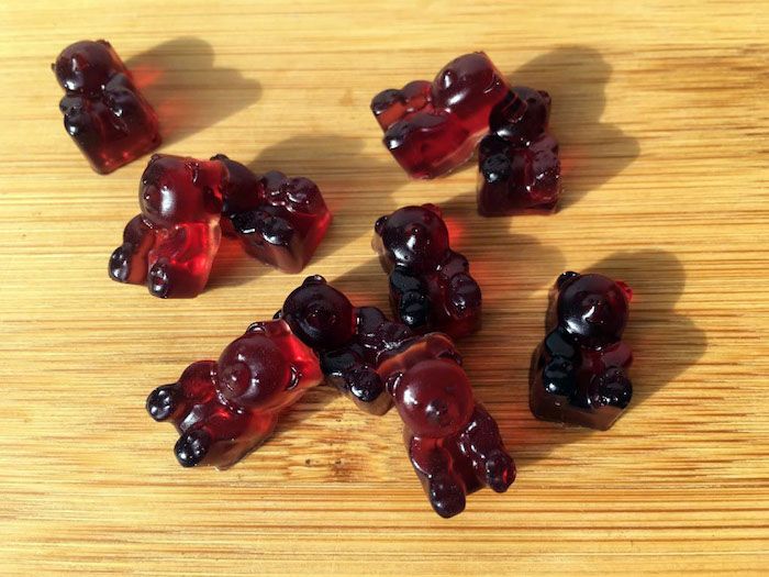 Gummy bear oppskrift - små røde gummy bjørner på en tre arbeidsplass