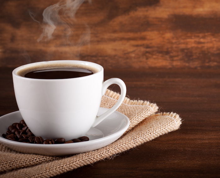 Bună dimineața cafea - o ceașcă de cafea neagră care este destul de fierbinte pe o masă de lemn
