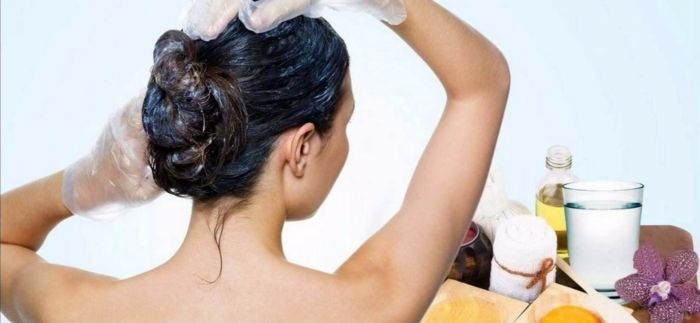 prírodné lieky proti vypadávaniu vlasov, masáž hlavy s éterickými olejmi, žena v kúpeľni, aplikujte masku na vlasy