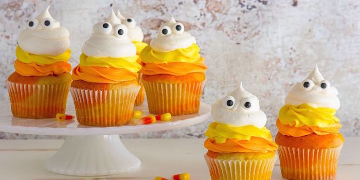 Cozimento de Halloween, pequenas sobremesas decoradas com abóbora com creme de laranja, amarelo e branco