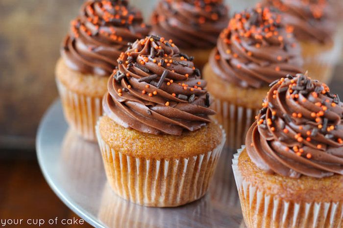 Decorar muffins, cupcakes de baunilha com creme de manteiga de chocolate e granulado