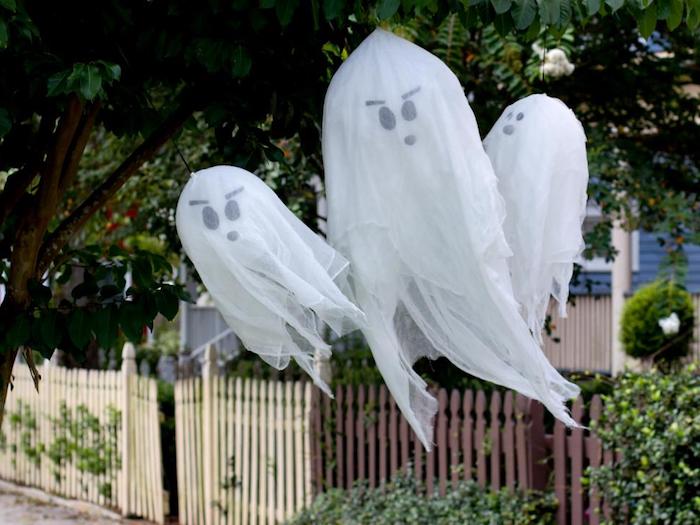 nuo medžio pakabinti trys vaiduokliai - baisi Helovyno kūryba