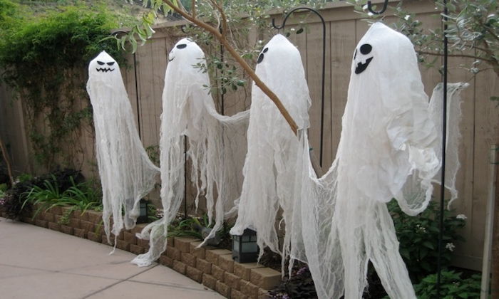 keturi juokingi vaiduokliai ant tvoros, kabantys nuo kapai - patys Halloween apdaila