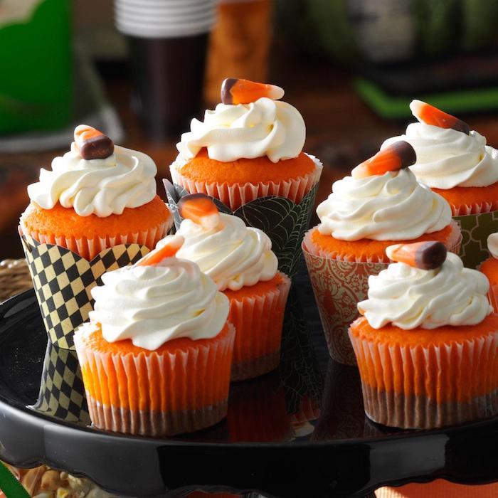 Helovyno pyragas, cupcakes oranžinės ir rudos papuoštos grietinėlės ir želė saldainiais