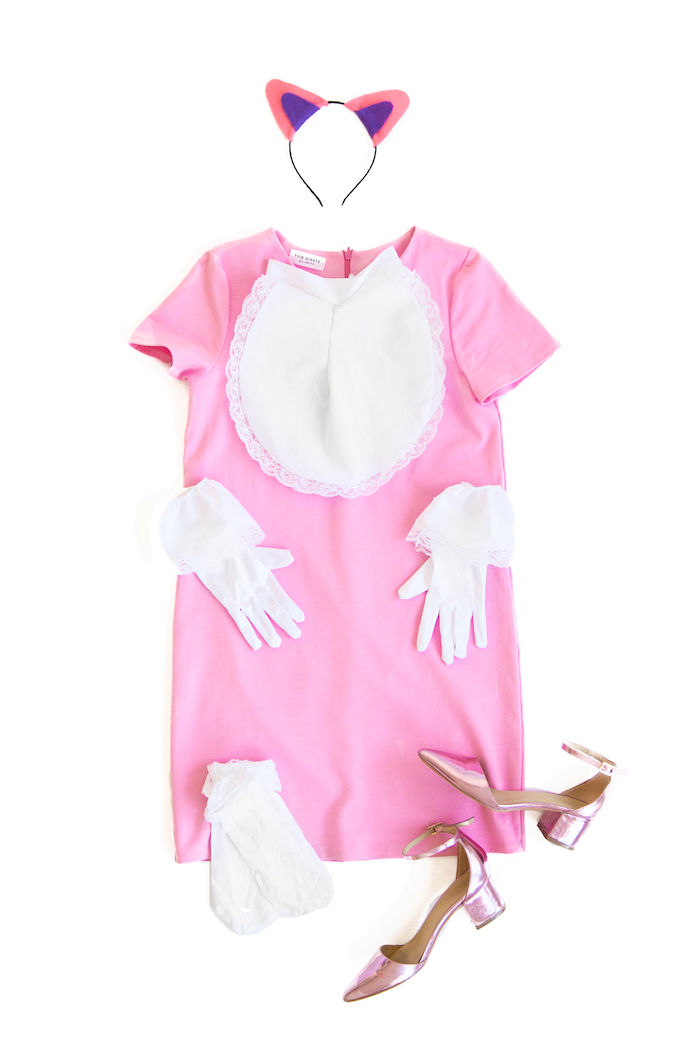 un costum roz de pisică în rochie roz, mănuși albe și șosete