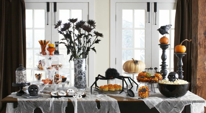 Halloween bord dekoration, svarta blommor, ravn och skalle, festmat kex och popcorn