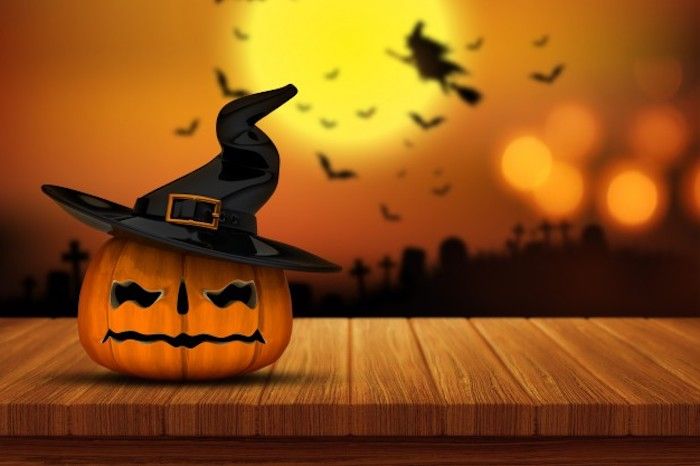 een pompoen met heksenhoed - Halloween-achtergrond met vele silhouetten