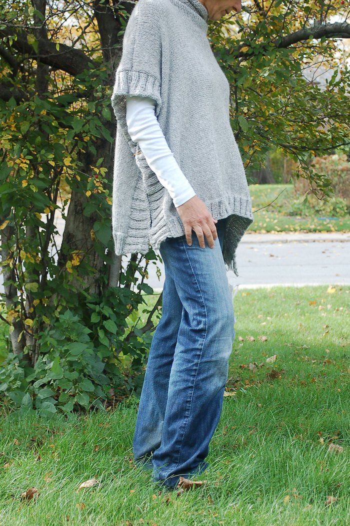 strikk en grå poncho med mønster på kanter kombinert med jeans