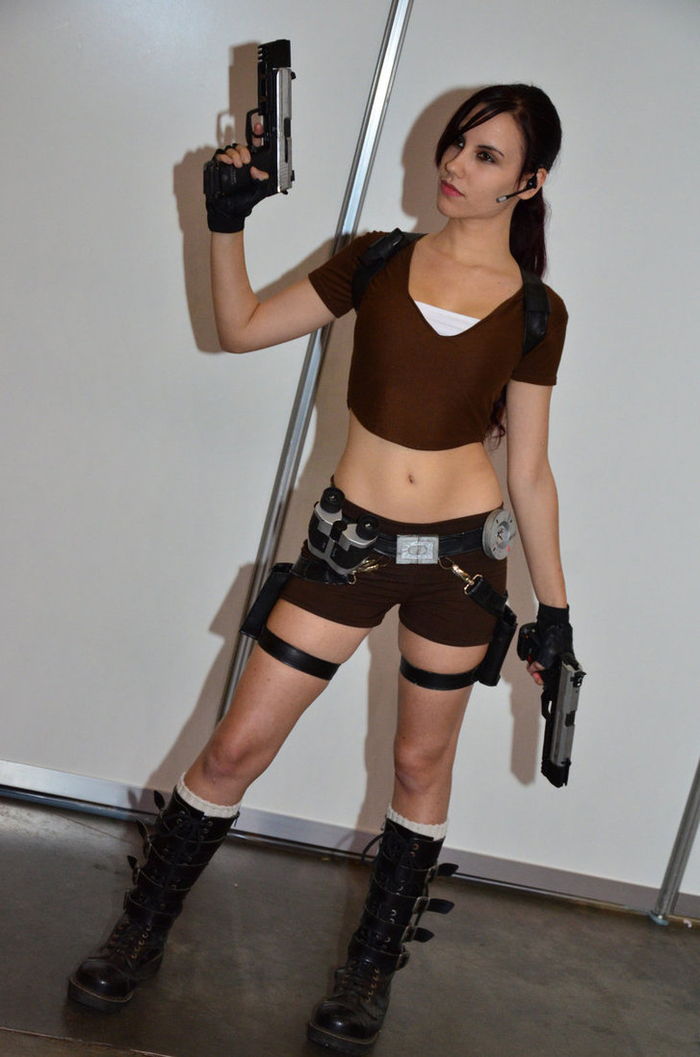 Lara Croft från spelet Tomb Raider med två pistol shorts och kropp i bruna färg-barndoms hjältar