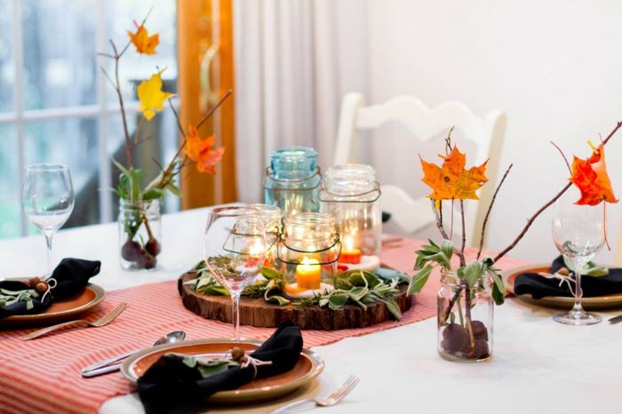 układanie stołu jesiennego, jesiennych liści i kasztanów w konserwujących słoikach, małych lampionach