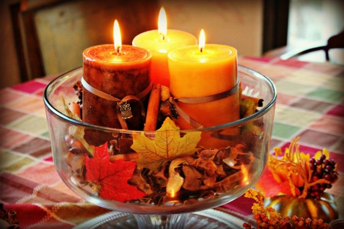 usporiadajte stolík jesenne, sviečky v jesenných odtieňoch a jesenné lístie v sklenenej miske