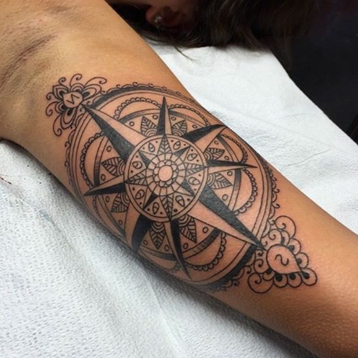 Aceasta este o idee foarte buna pentru un tatuaj negru mare cu o busola neagra cu motive de mandala - un tatuaj pe mana