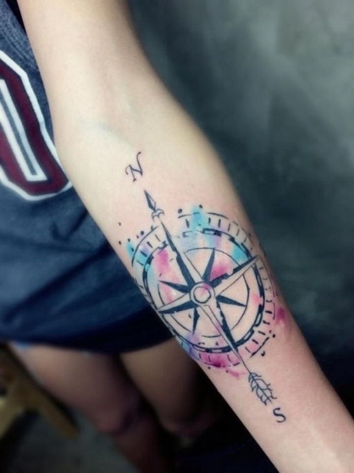 To jeden z najpiękniejszych kolorowych tatuaży z dużym czarnym kompasem - pomysł na tatuaż kompasu na ręce młodej kobiety