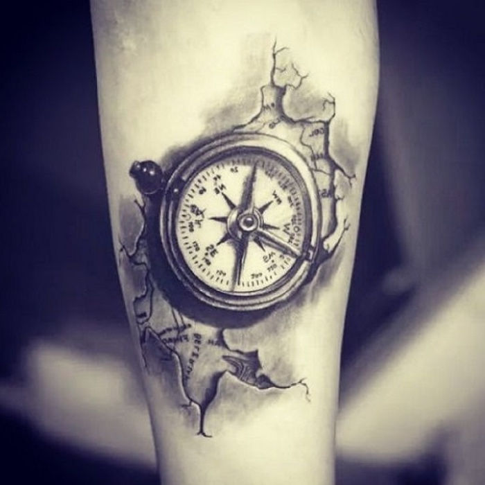 To pomysł na tatuaż kompasowy na rękę - mapę świata i mały czarny kompas