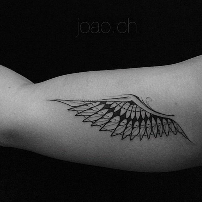 Ročica z majhnim črnim tetovažem angelskega krila z dolgimi črnimi peruti