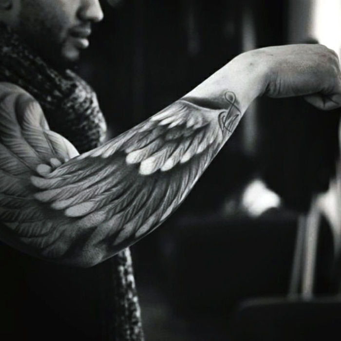 een andere man met een mooie zwarte tattoo - hier is een engelentattoo met engelenvleugels met witte veren