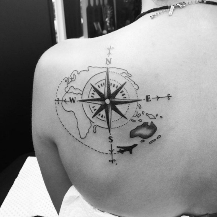 to świetny pomysł na tatuaż kompasu na ramieniu - czarny tatuaż z kompasem i mapa świata na schuoterblatcie i samolocie