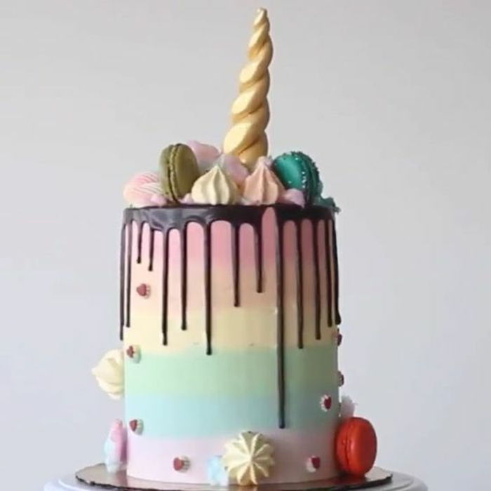 Aqui está uma torta de unicórnio colorido com um chifre