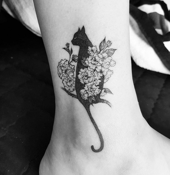 Aici veți găsi o idee grozavă cu privire la tatuajul pisicilor pe picior - o pisică neagră și flori albe