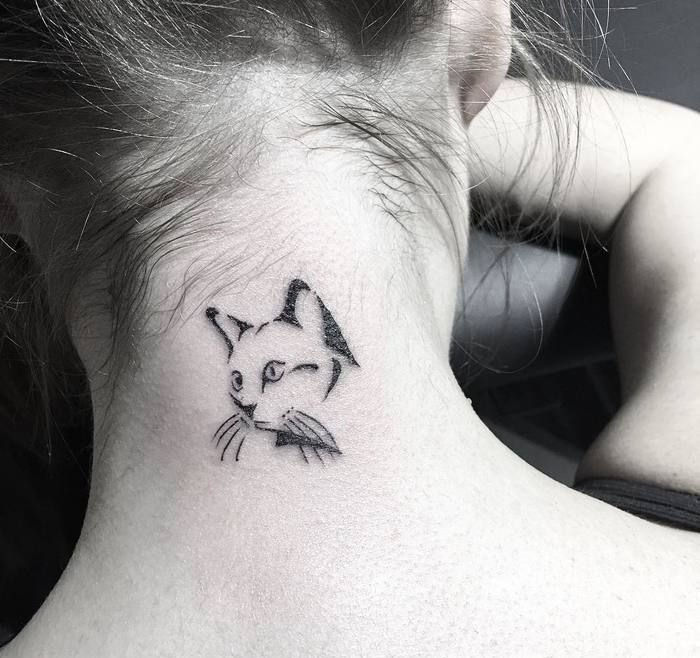 Ideea pentru un tatuaj mic de pisici frumos pe lambă pentru doamne - o pisică neagră cu vibrații negre