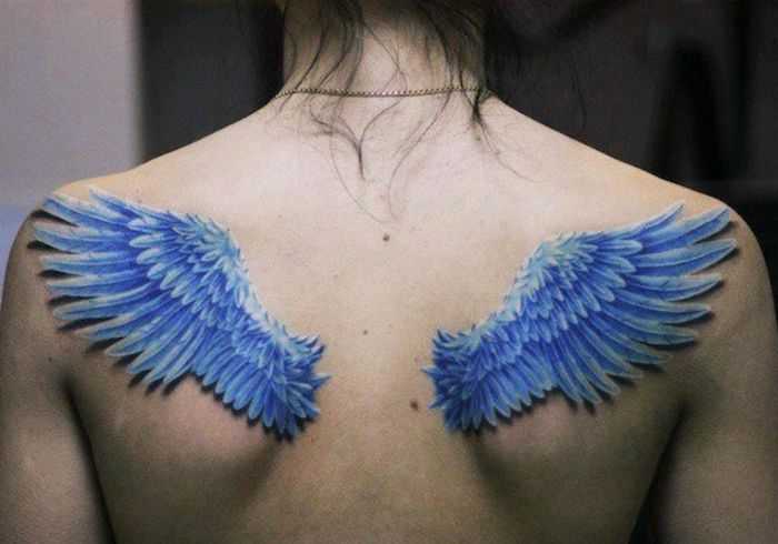Een vrouw met twee kleine blauwe engelenvleugels met blauwe lange veren - nog een idee voor een vleugevleugel-tattoeage