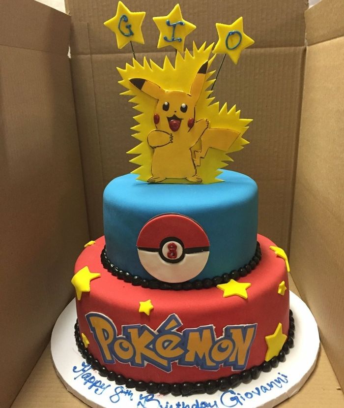 Bela torta de pokemon de dois andares com estrelas e manchetes amarelas e um pequeno pikachu de essência de pokemon