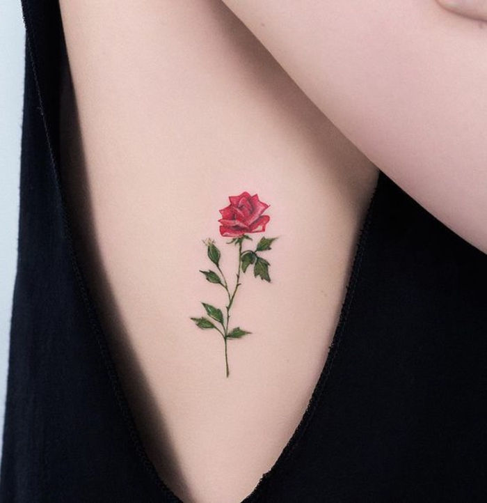 ecco una delle nostre idee per un grande tatuaggio con una rosa rossa con foglie verdi - idea per un tatuaggio per le donne - modello di tatuaggio rose