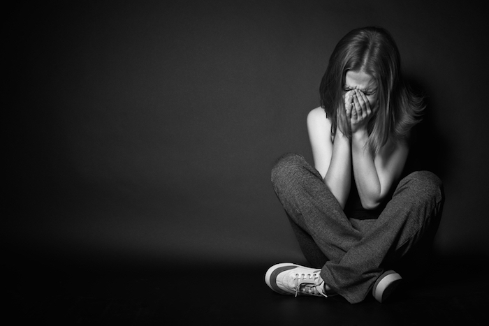 mladá smutná žena pláči, čierna stena - smutné obrázky na plač