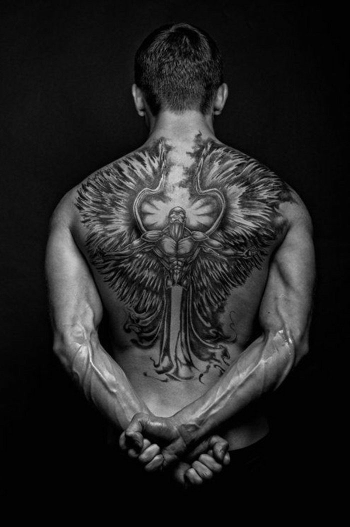 świetny pomysł na tatuaż z czarnym aniołem, który mężczyźni mogą bardzo lubić - tu jest mężczyzna o czarnym tatuażu anioła z długimi piórami