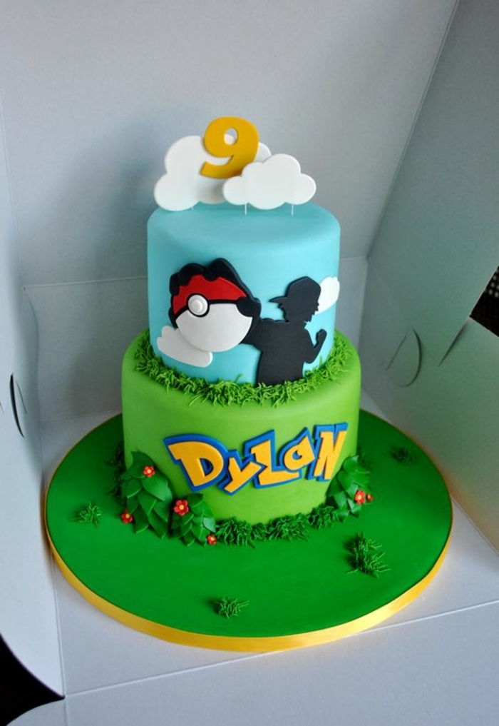 bolo de pokemon de dois andares com nuvens, flores e uma pokeball vermelha e grama