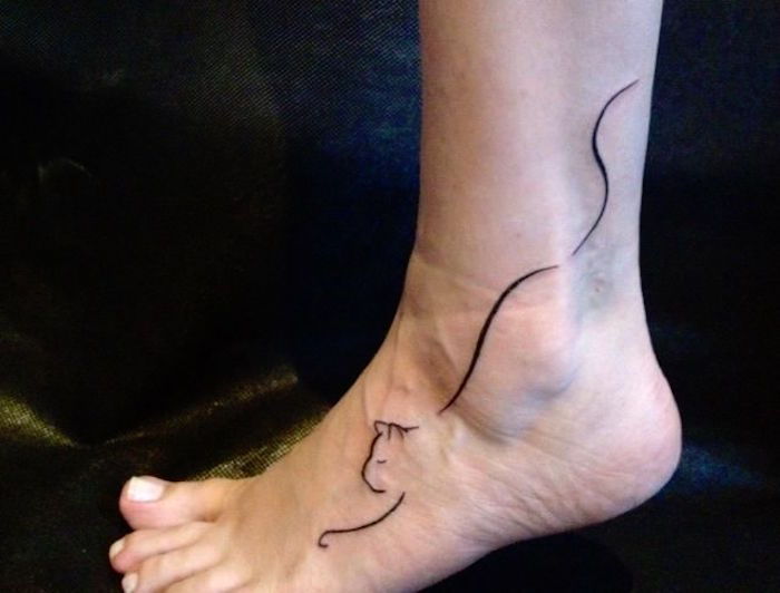 un picior, un călcâi, o pisică neagră - o idee pentru un tatuaj de pisică