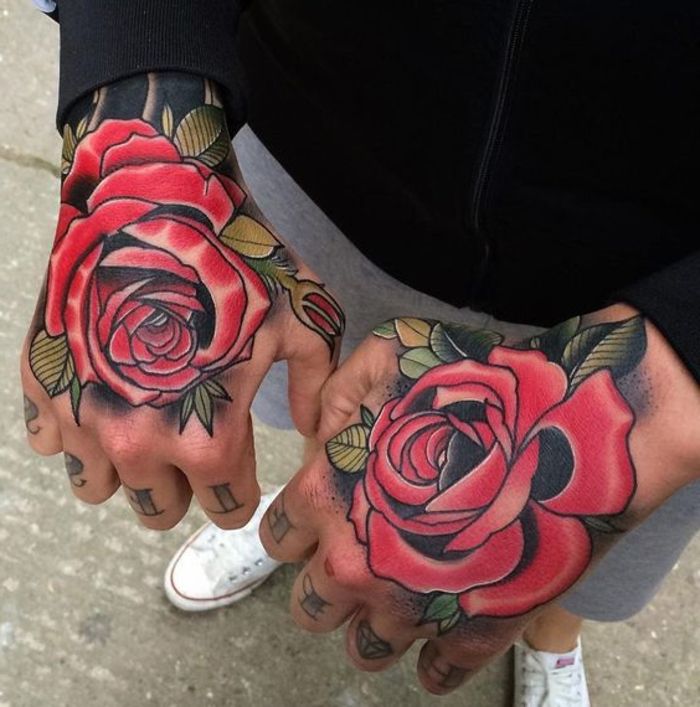 Hier vindt u twee handen met rode roos tatoeages en groene bladeren - idee voor de mannen