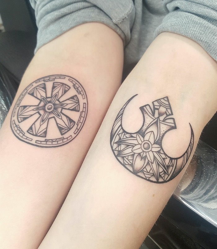 două mâini cu tatuaje ale războaielor de stele cu două logouri războaie și flori mici cu frunze