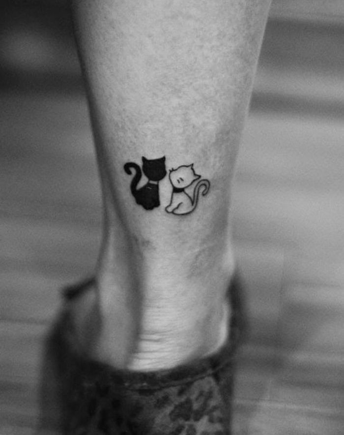 încă una dintre ideile noastre privind subiectul tatuajului pisicilor pe picior - o pisică neagră și o pisică albă albă cu vibrații negre
