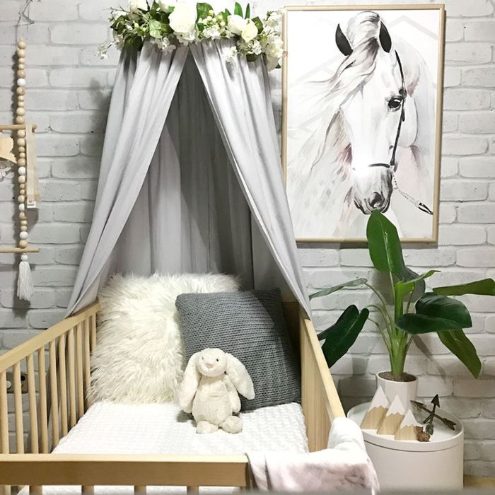 Baby seng med himmel og blomsterkrans, baby rom for jenter i pastellfarger, bilde med hest, potteblomst