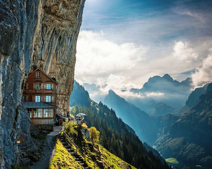 Casa de montanha com vistas deslumbrantes, montanhas pontiagudas, raios de sol