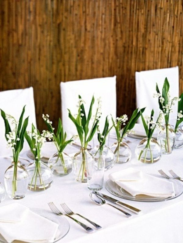 Vestuvinės stalinės gėlės puodeliuose ir baltos kėdės