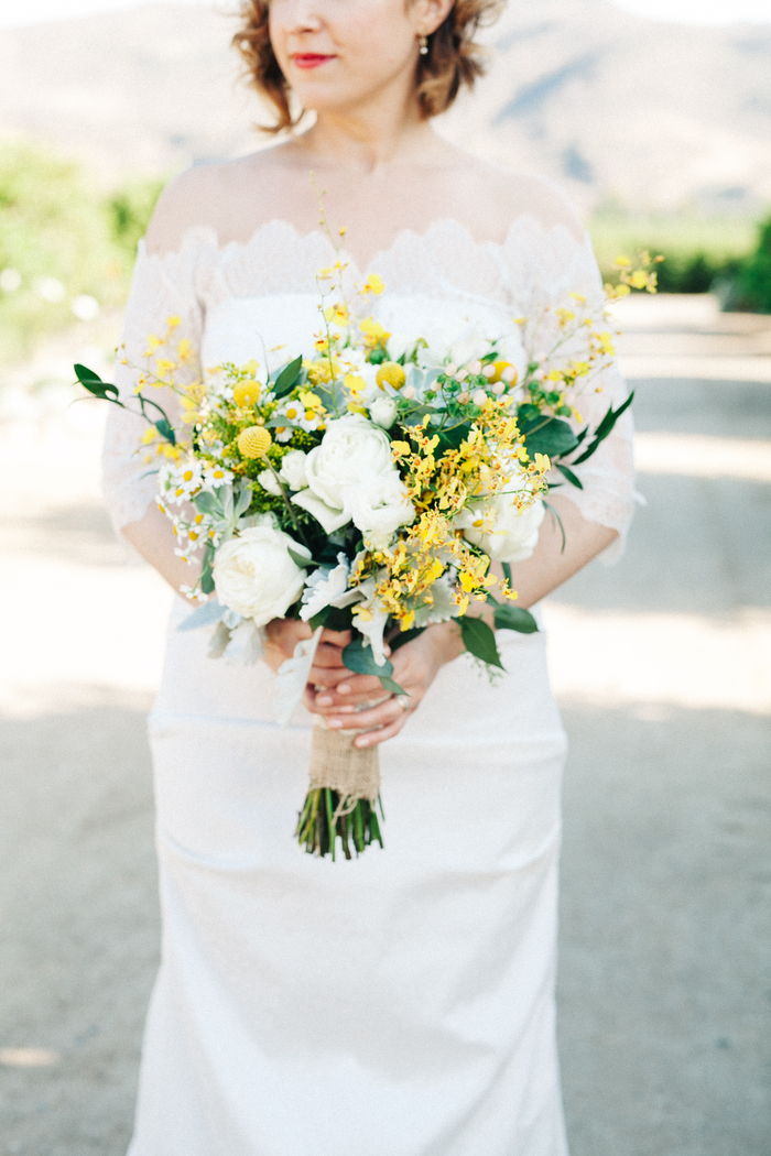 vacker vit brudklänning, gula blommor och vita rosor i vintage brudbukett