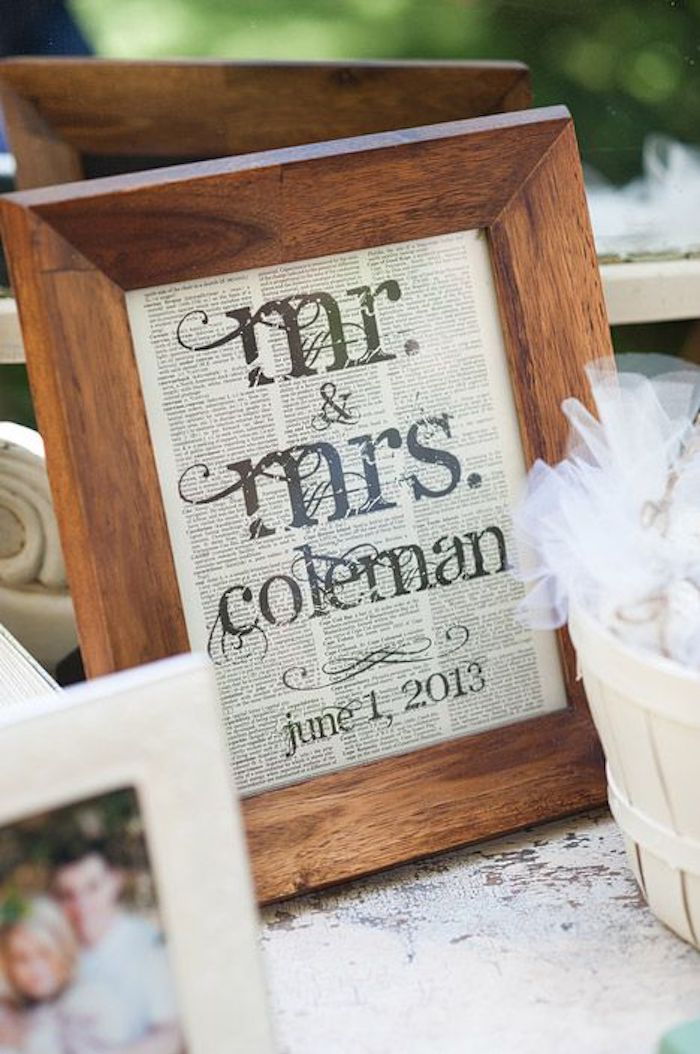 drevený fotorámček so svadobnými papiermi a rodina novomanželov